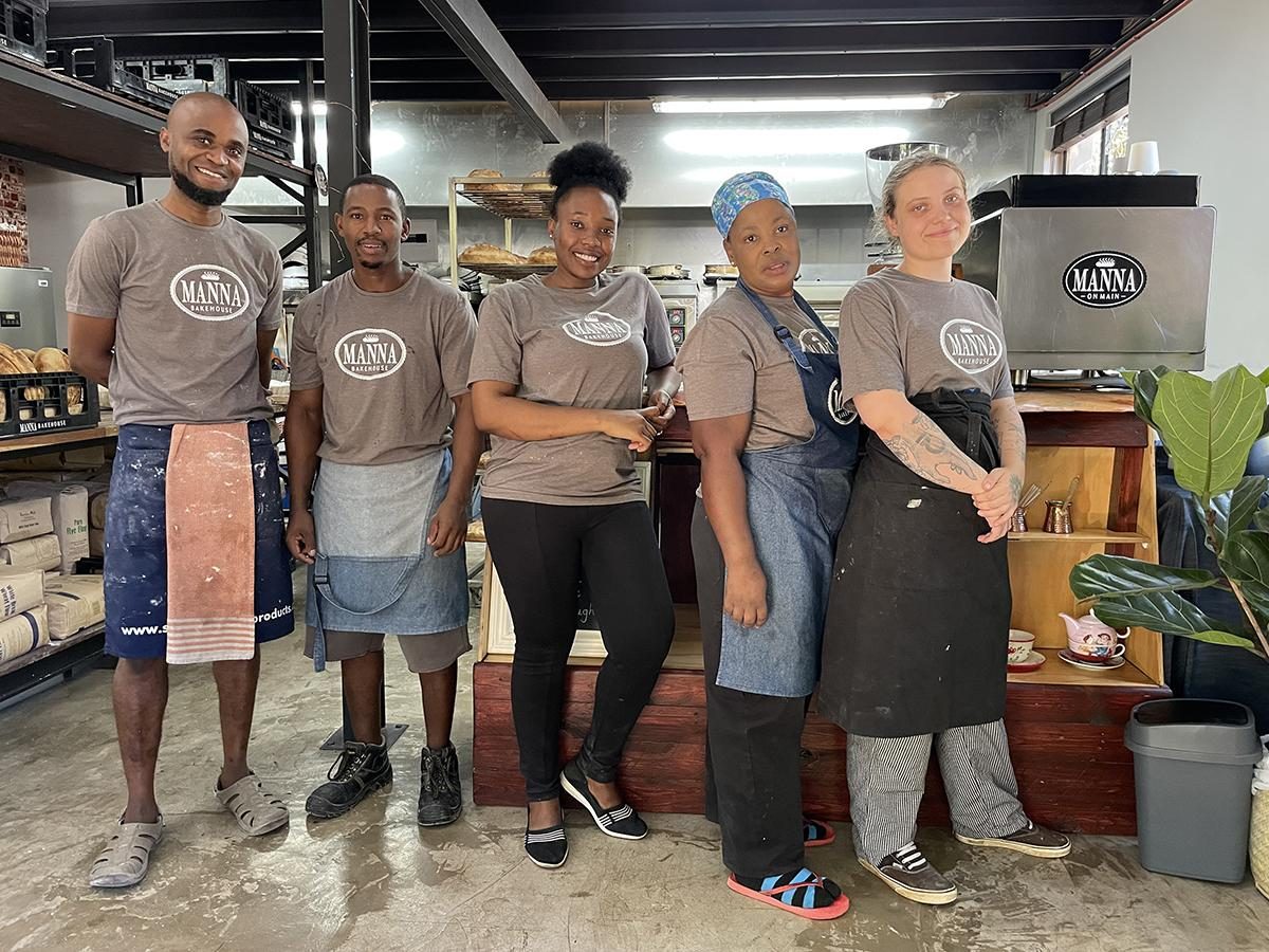 The Manna Bakehouse team in branded tees inside the bakehouse